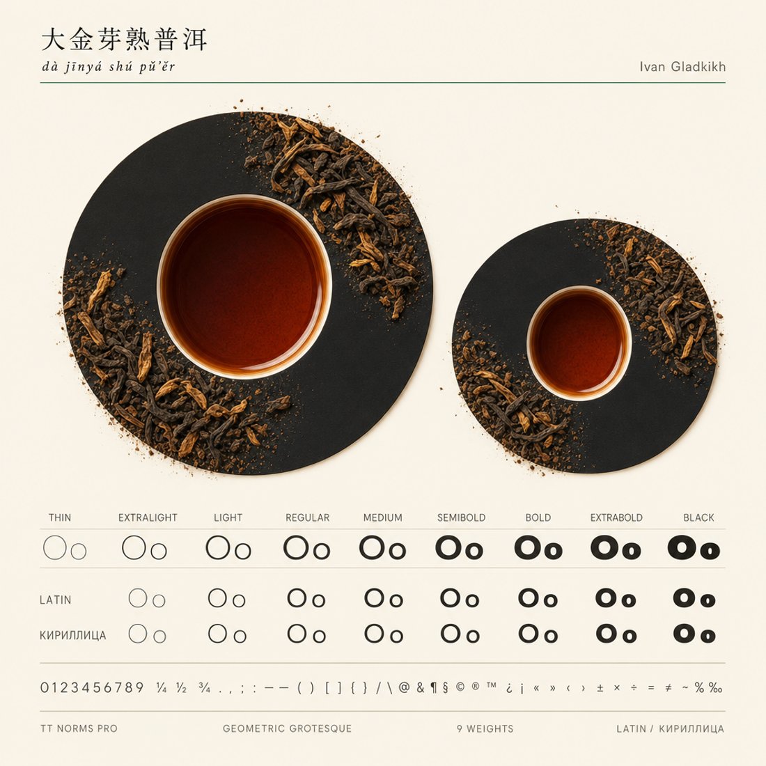 A huge black letter O on white with broken pieces of dark pu-erh resin resting inside its counter above a weight ladder